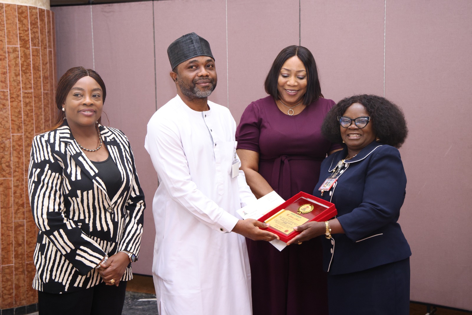 R-L: Representative of the Permanent Secretary State House, Mrs Adenike Akintola, presenting an award to Dr. Agbor Ebuta, flanked by Mrs Abimbola Olusola, Head of the Procurement Department and Dr Vicky Ogala-Akogwu, Chairman, Medical Advisory Committee, State House Medical Centre at the 2025 State House Ministerial Rewards and Recognition Ceremony at the State House.